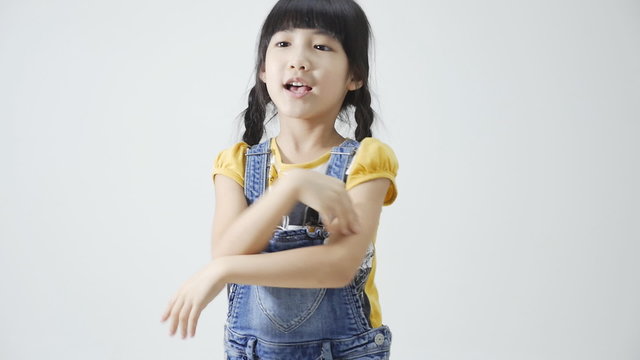 Little Asian girl singing and dancing on white background