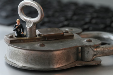 Internet security concept-miniature businessman stand on old key