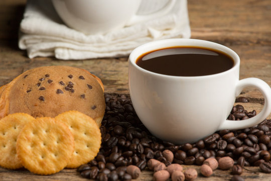Cup of coffee on a wooden board and biscuits
