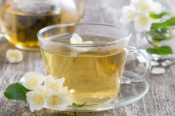 kettle and a cup of green tea with jasmine, close-up