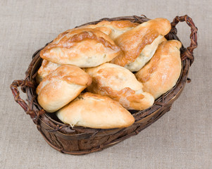 Homemade patties by grandma in a wooden vintage basket on a gray sackcloth background