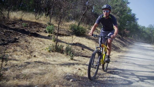 Man riding mountain bike on dirt road 