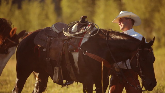 Group of cowboys saddle up and prepare for ride