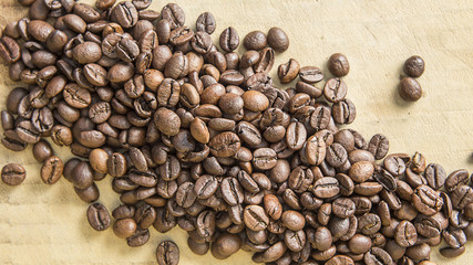 Brown coffee beans isolated on a wooden background