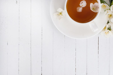 Fototapeta na wymiar A cup of green tea with jasmine on a white surface