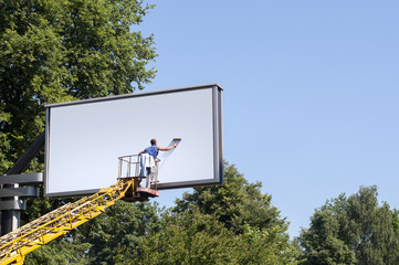 Man putting a new, blank poster to a billboard - obrazy, fototapety, plakaty