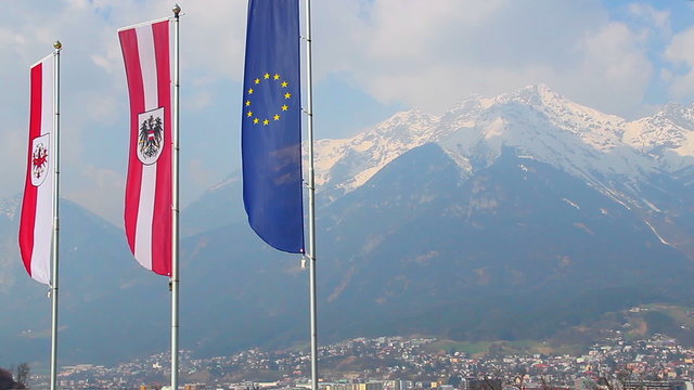 Flags with EU, Austria, Tyrol signs, majestic Alps on background