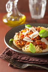 italian pasta spaghetti bolognese with basil on rustic table