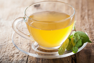 herbal sage tea with green leaf in glass cup