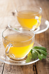 herbal sage tea with green leaf in glass cup