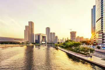 modern skyscrapers and skyline during sunset at riverbank