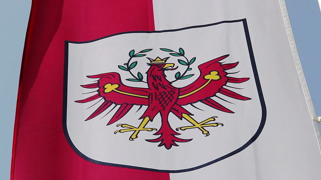 Flag with Tyrol coat of arms waving in wind, state of Austria