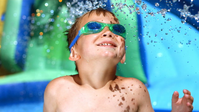 Young boy playing on water slide