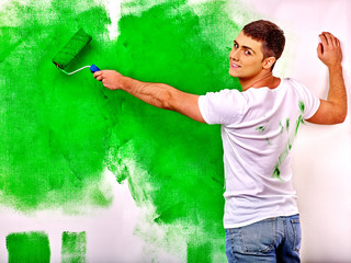 Obraz premium man paint wall at home.