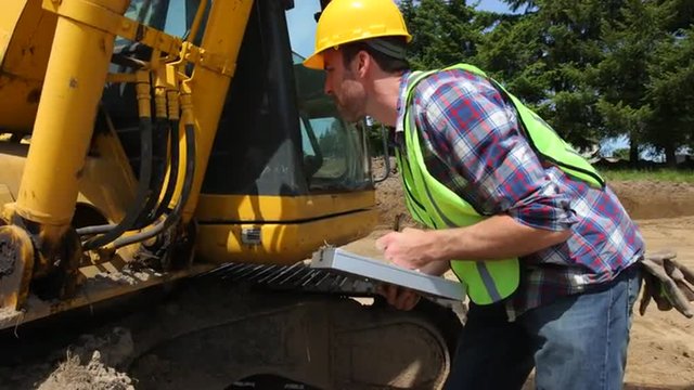 Worker inspecting excavation equipment