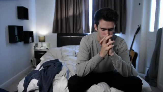 Video of depressed teenage boy alone in his bedroom