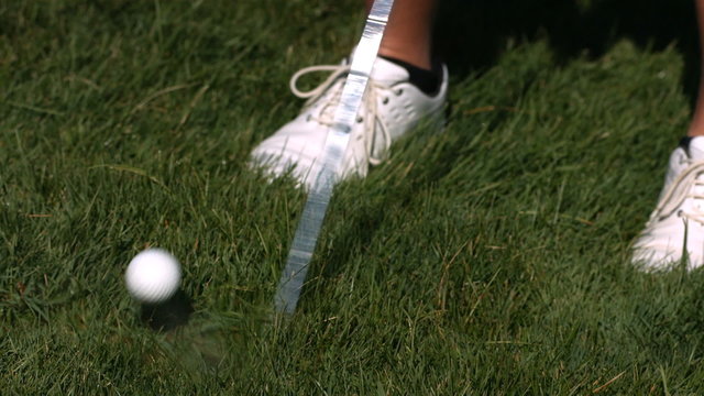 Golfer hits ball out of the rough, slow motion