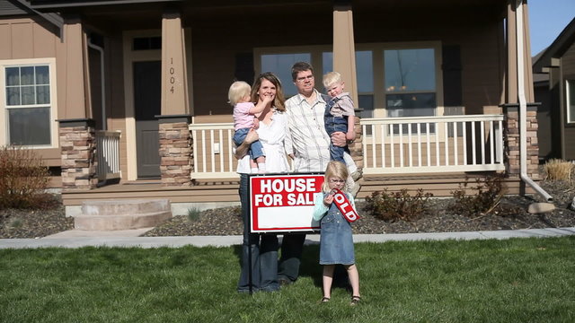 Happy family in front of their new house 