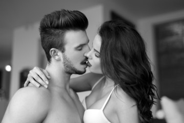 Sexy couple kissing at home black and white