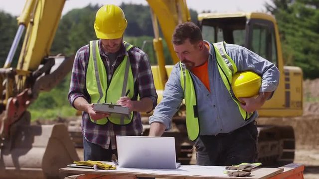 Construction workers looking at laptop computer