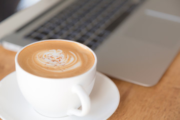 laptop with coffee cup on old wooden table ( Filtered image proc