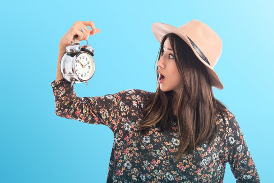Surprised woman holding vintage clock