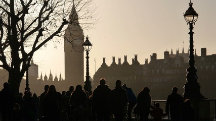 Silhouettes of pedestrians. Boulevard on the River Thames in London with the Big Ben in the background. - Powered by Adobe