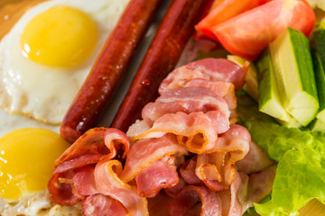 Toasts, fried egg, sausages, meat and vegetables
