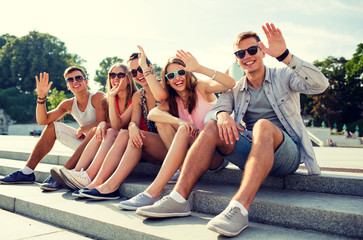 group of smiling friends sitting on city street