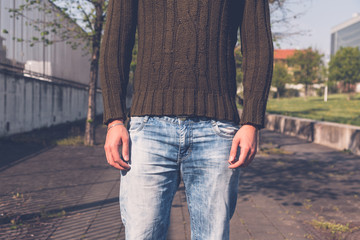 Detail of a young  man posing in an urban context