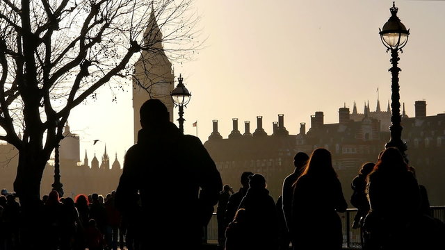Silhouettes of pedestrians. Boulevard on the River Thames in London with the Big Ben in the background. 