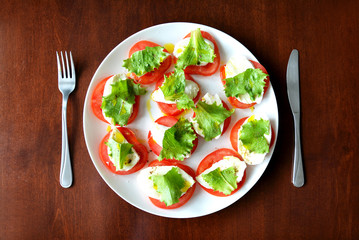 Tomatoes with mozzarella and lettuce on a plate