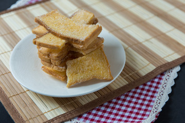 Stack of sliced crispy buttered bread with sugar