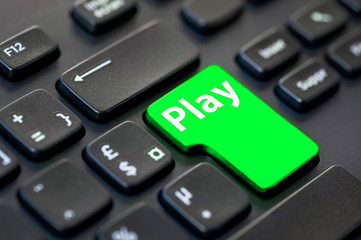 Close up of a green return key with the word play on computer keyboard