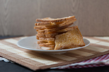 Stack of sliced crispy buttered bread with sugar