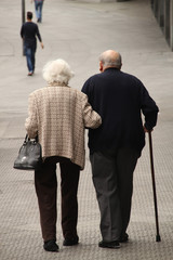 Pareja de ancianos caminando juntos por la calle