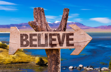 Believe direction sign with landscape background