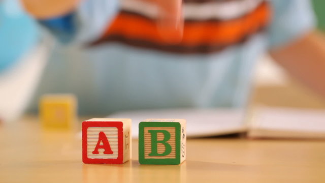 Young boy plays with alphabet blocks