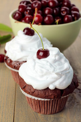 Chocolate Cupcakes with cherries on wooden background