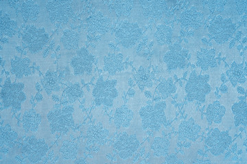 blue background Satin fabric with floral pattern closeup