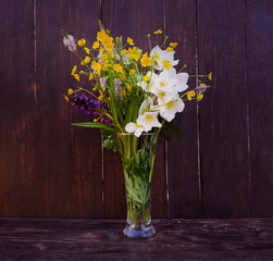 Bouquet of wild flowers on a wooden background in vintage style