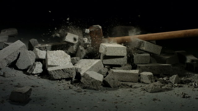 Sledge hammer hitting concrete bricks