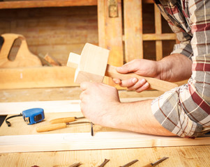 Closeup of a carpenters hands working with a chisel and carving tools