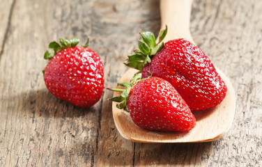 Fresh strawberries in a wooden spoon, selective focus