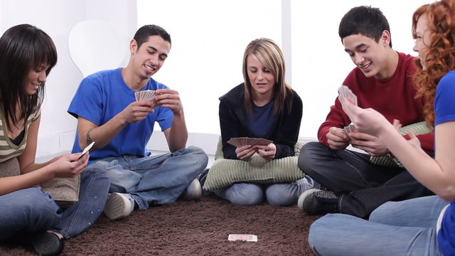 Group of teens playing cards together