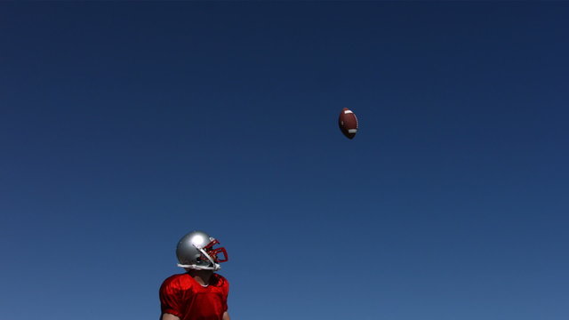 Football player makes diving catch, slow motion