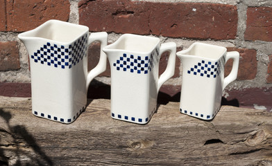 Alte, gemusterte Keramik Kännchen / Kanne / Gefäß für Milch, Kaffee, Tee auf Treibholz Brett
