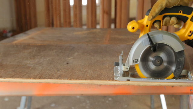 Closeup of construction worker cutting plywood