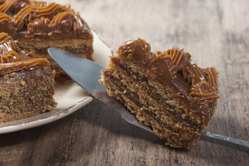 Piece of cake with honey shortcakes, cream boiled condensed milk