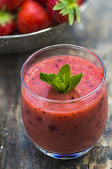 Fresh strawberry smoothie on wooden table